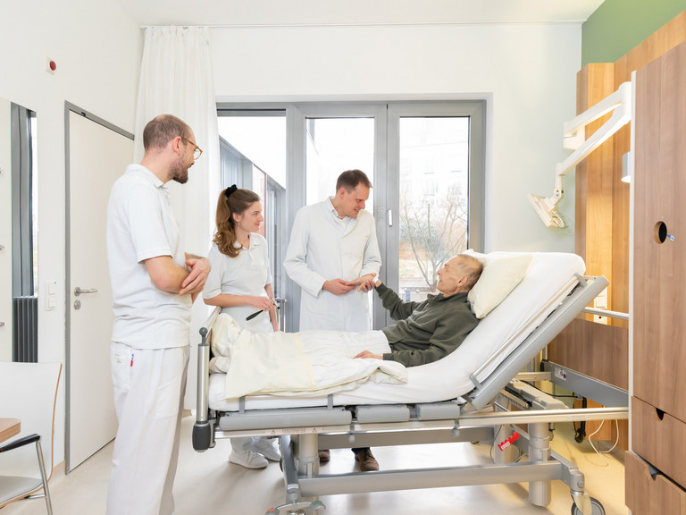 Prof. Kamp mit zwei Studierenden am Bett eines Palliativpatienten Prof. Kamp mit zwei Studierenden am Bett eines Palliativpatienten